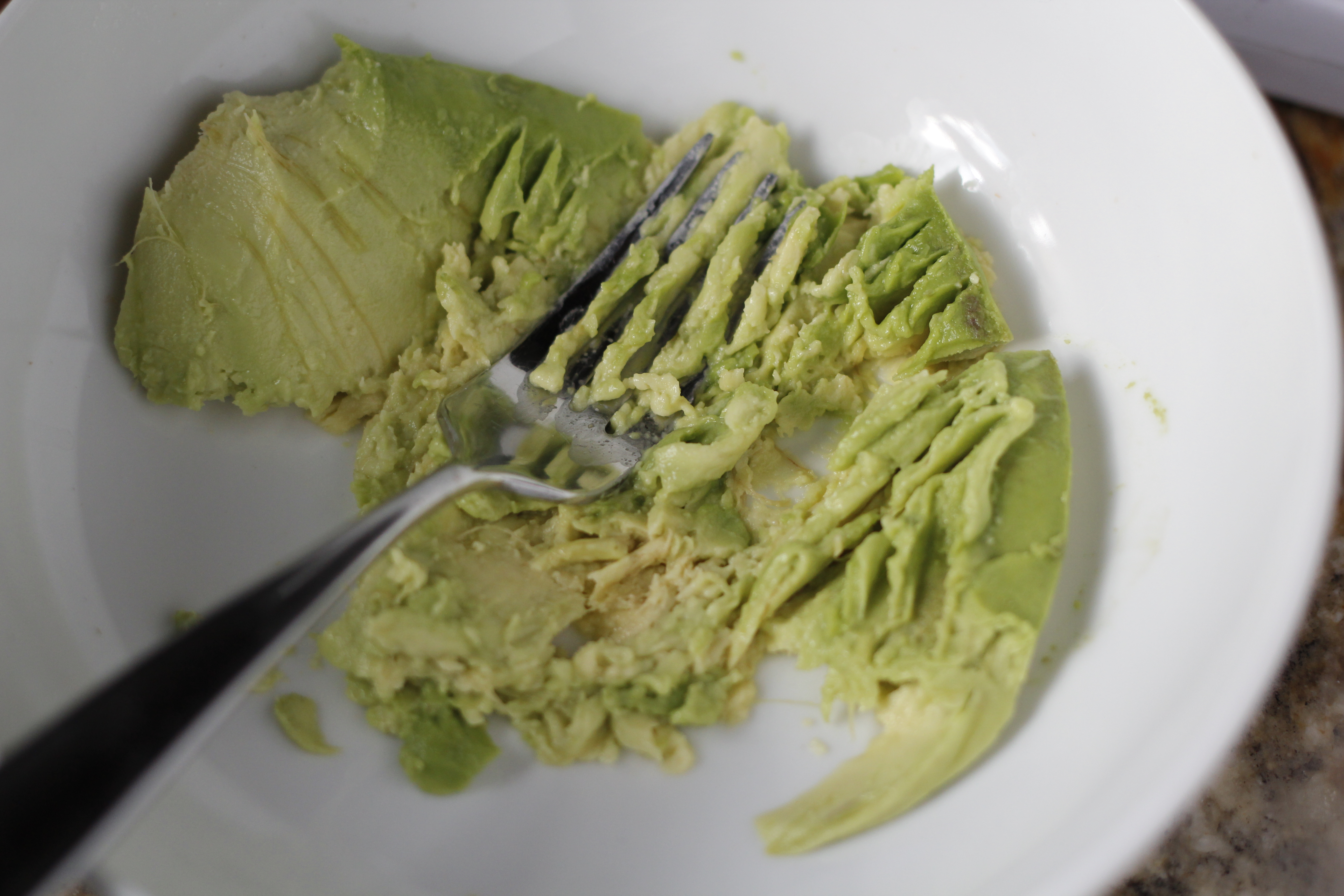 mashing avocado with fork.
