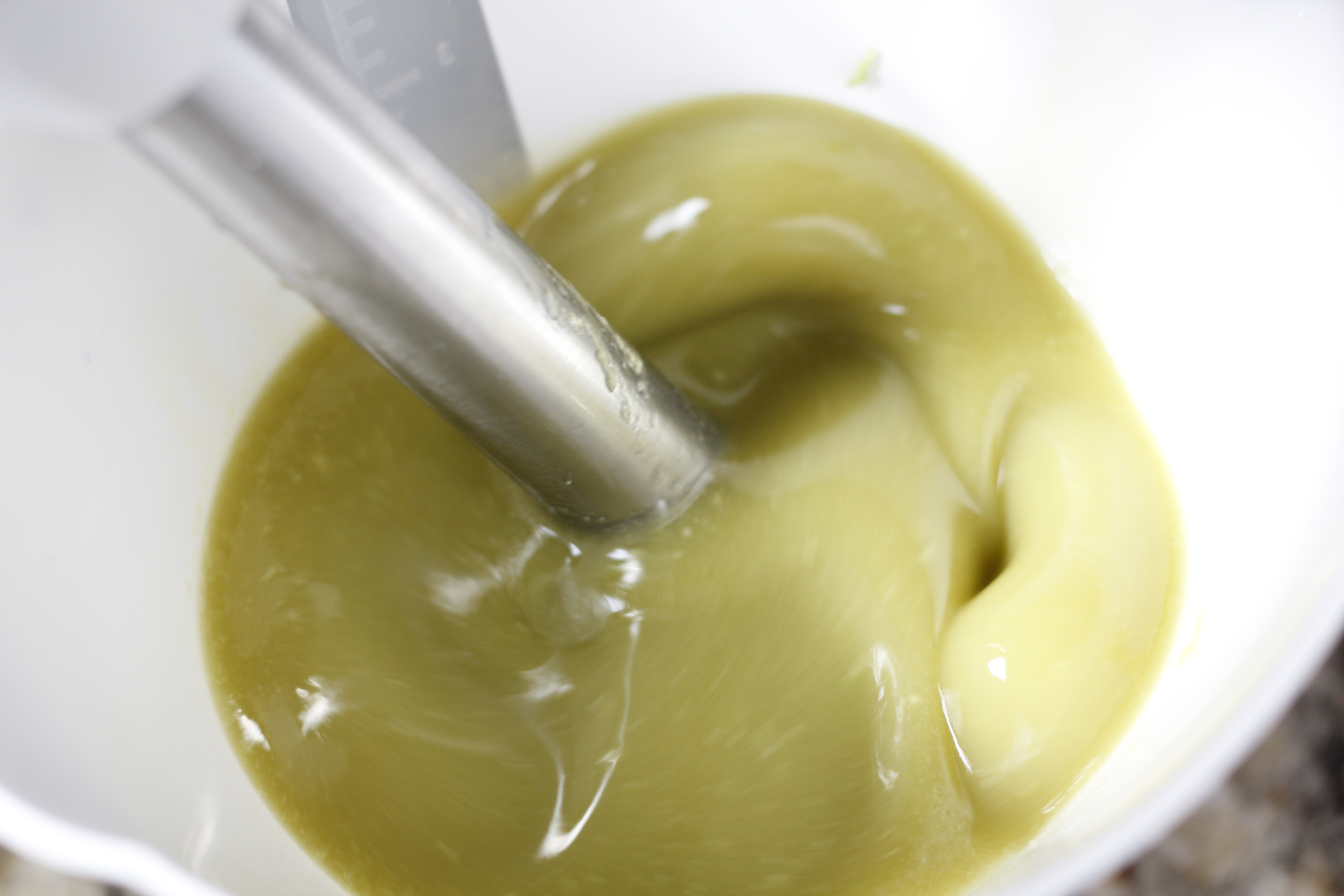 using immersion blender to incorporate avocado to oils.