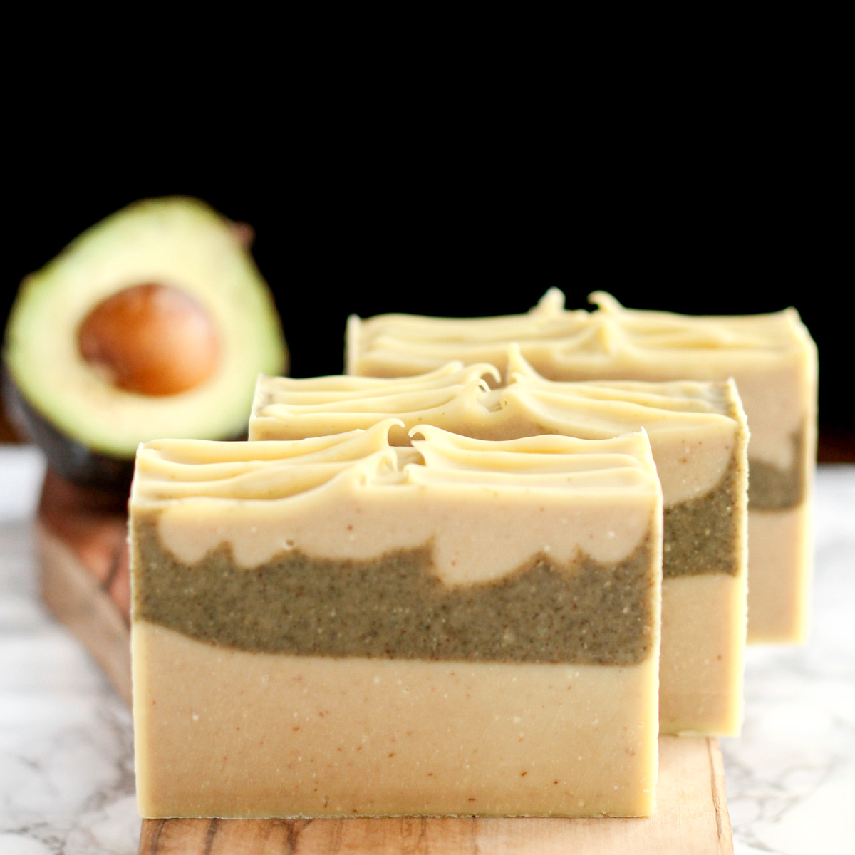 avocado soap bars with fresh avocado in background.