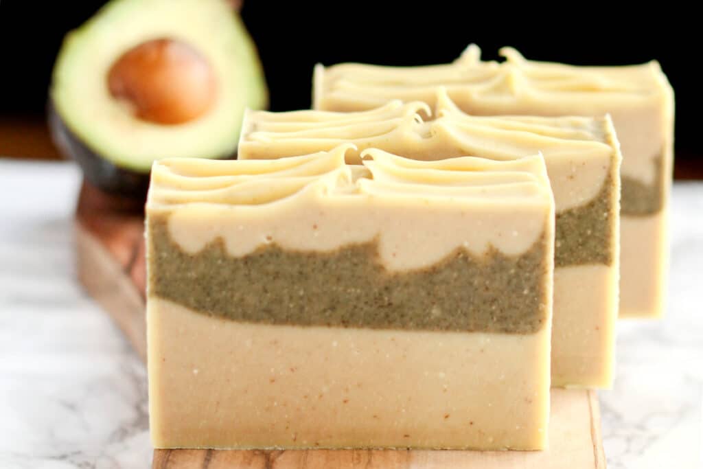 avocado soaps lined up with avocado in background.