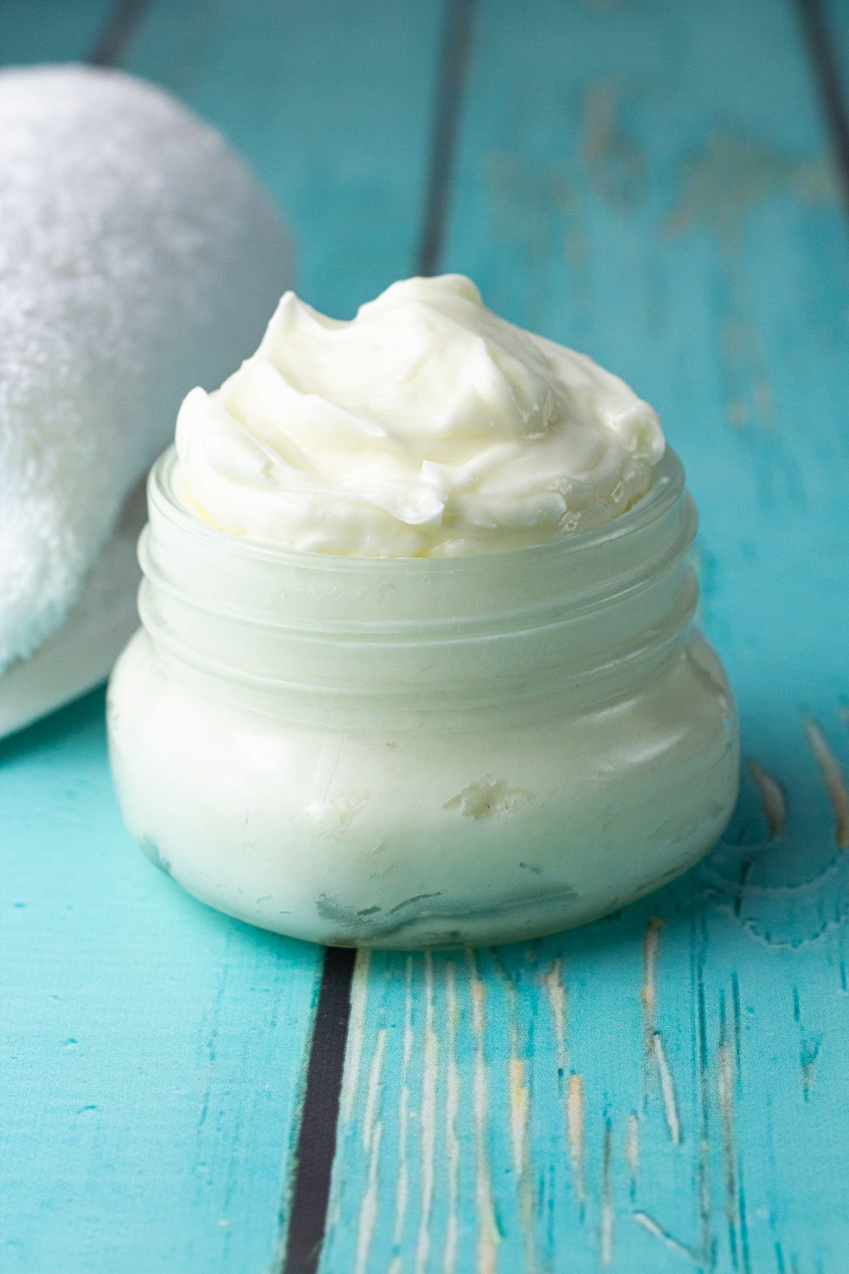 lotion in glass jar with towel.