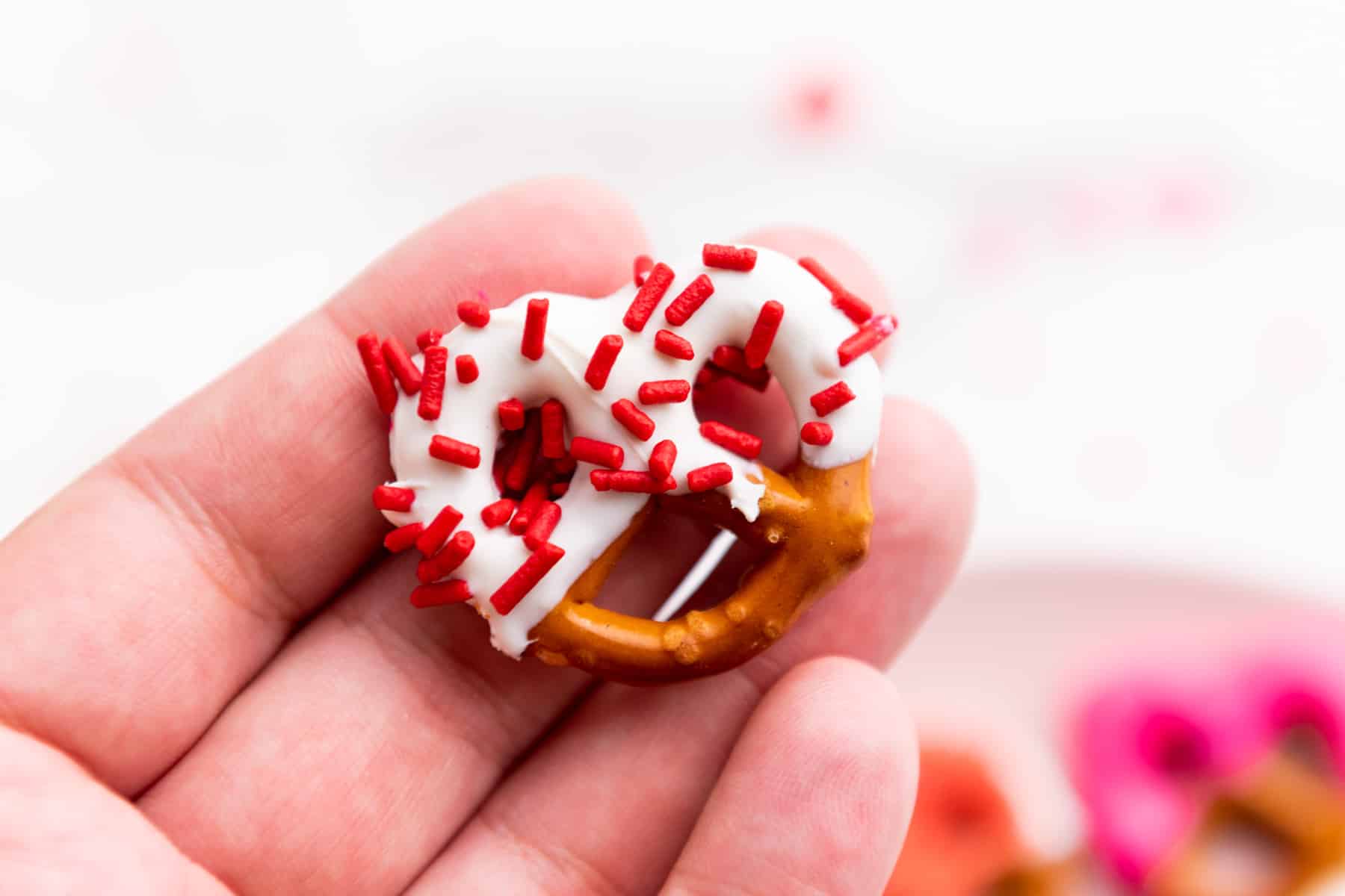 hand holding chocolate covered pretzel.