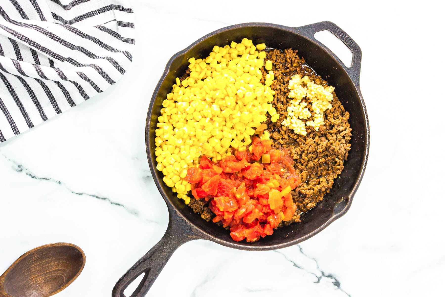 skillet with meat, corn, tomatoes and garlic.